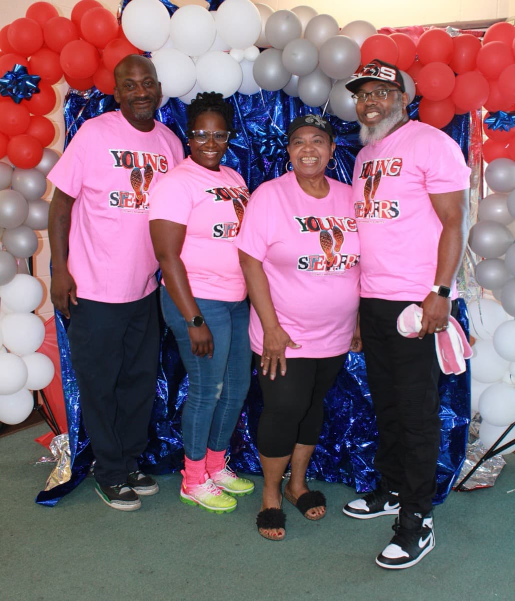 Young Steppers team members in matching pink shirts at community event